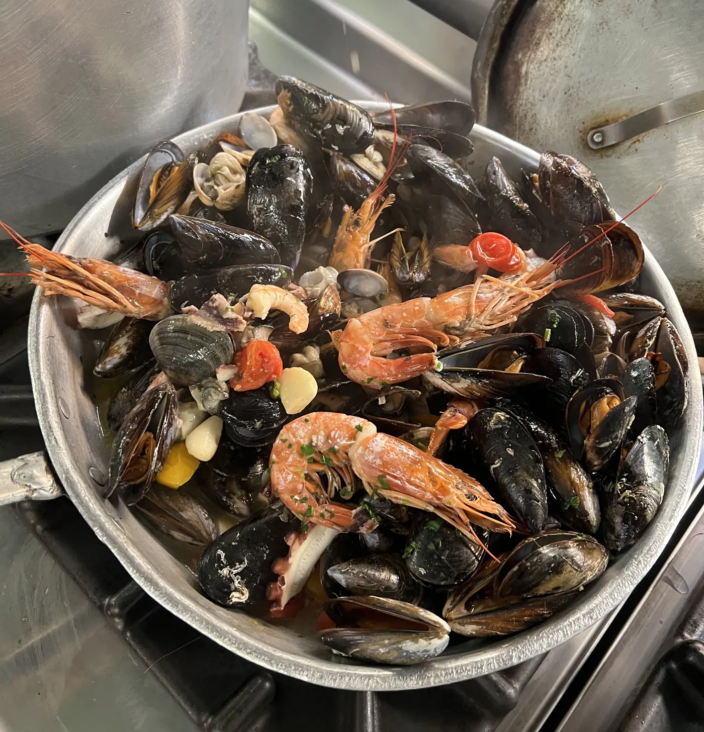 Cozze, vongole e gamberi in padella nella cucina del ristorante